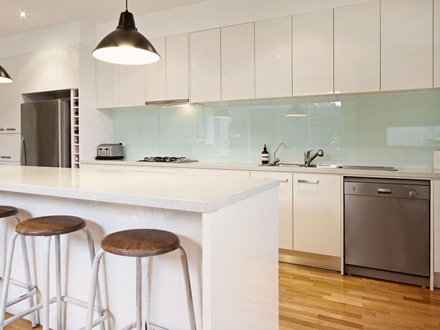 a kitchen with three stools next to an island