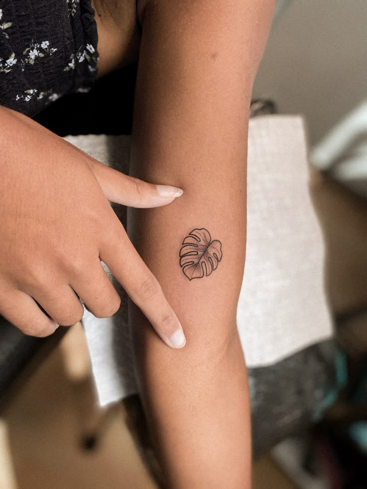 a woman's arm with a small tattoo on the left side of her arm