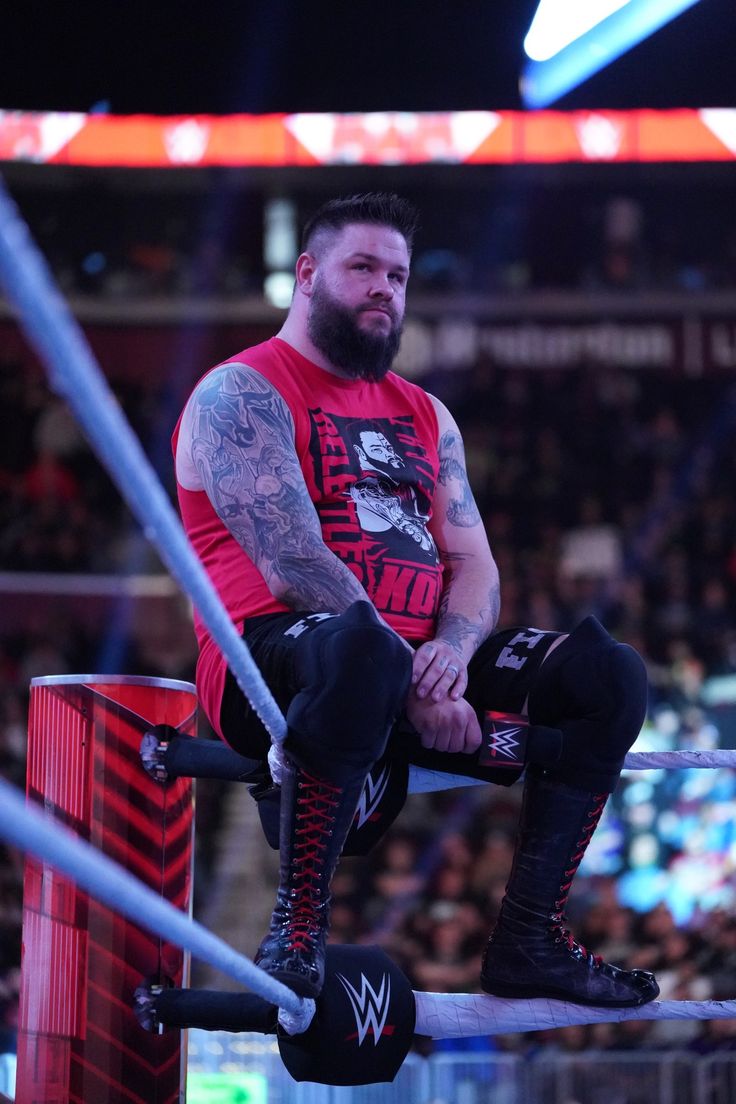 a man sitting on top of a wrestling ring