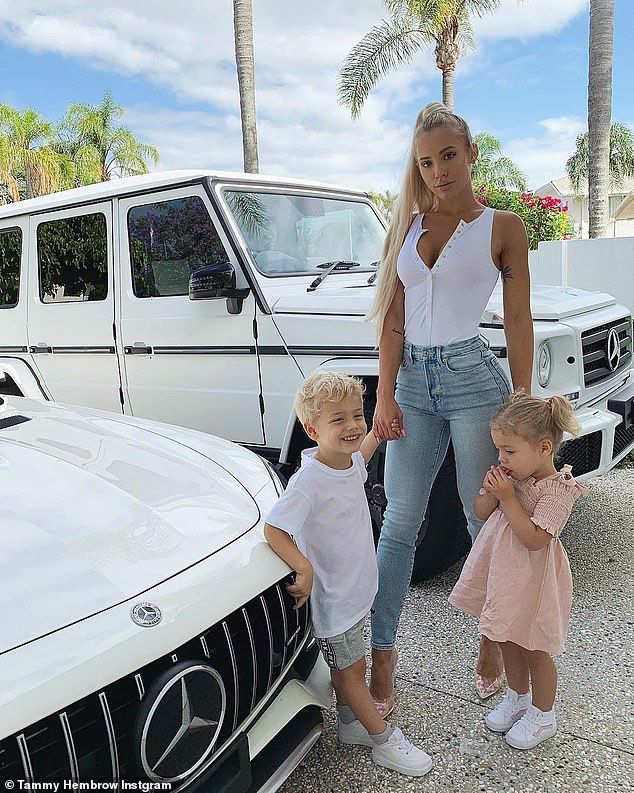 a woman and two children standing in front of a white mercedes benz car with palm trees behind them