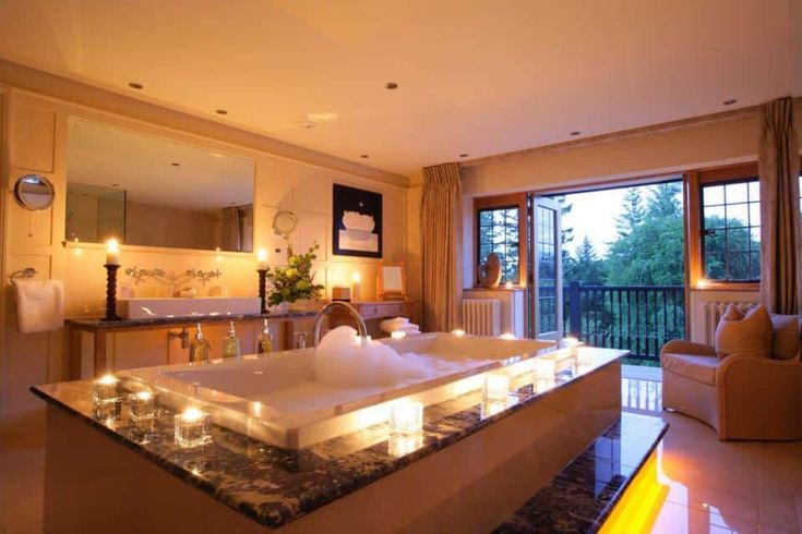 a large bath tub sitting in the middle of a living room next to a window