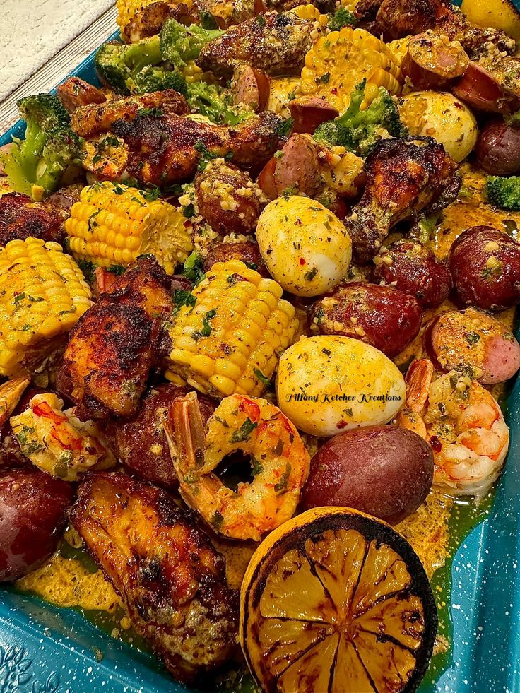 a blue tray filled with shrimp and corn on the cob