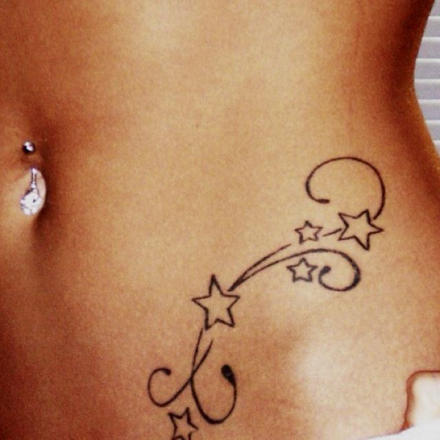 a woman's stomach with an arrow and stars tattoo on the side of her belly