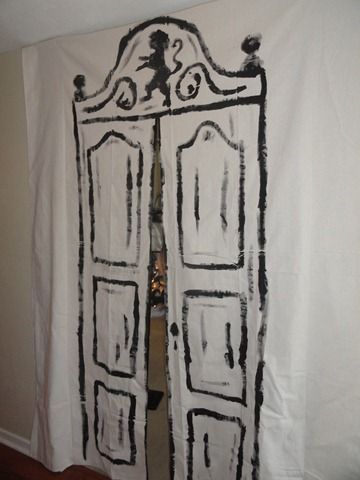 a white curtain with black paint on it hanging in front of a door that is open