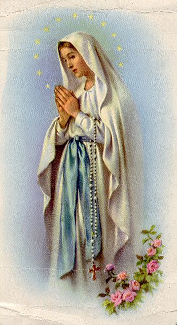 an image of the virgin mary holding her hands together with flowers in front of it