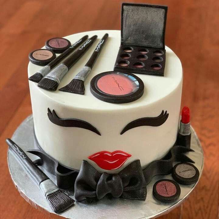 a cake decorated with makeup and accessories on a table