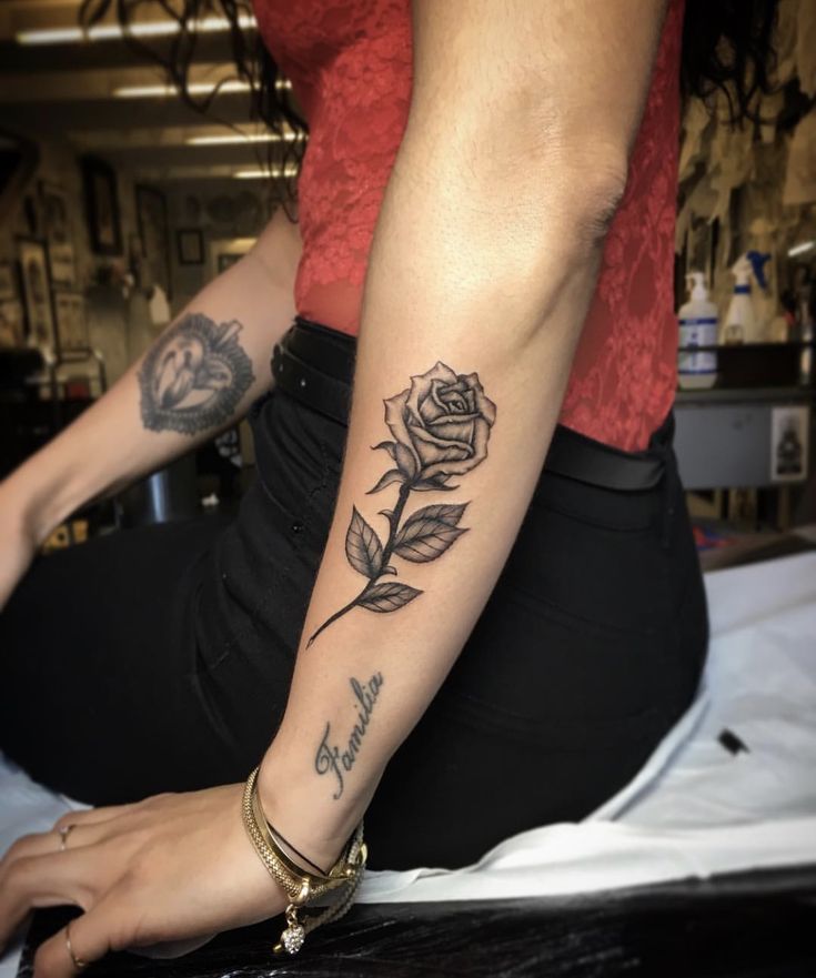 a woman with a rose tattoo on her arm