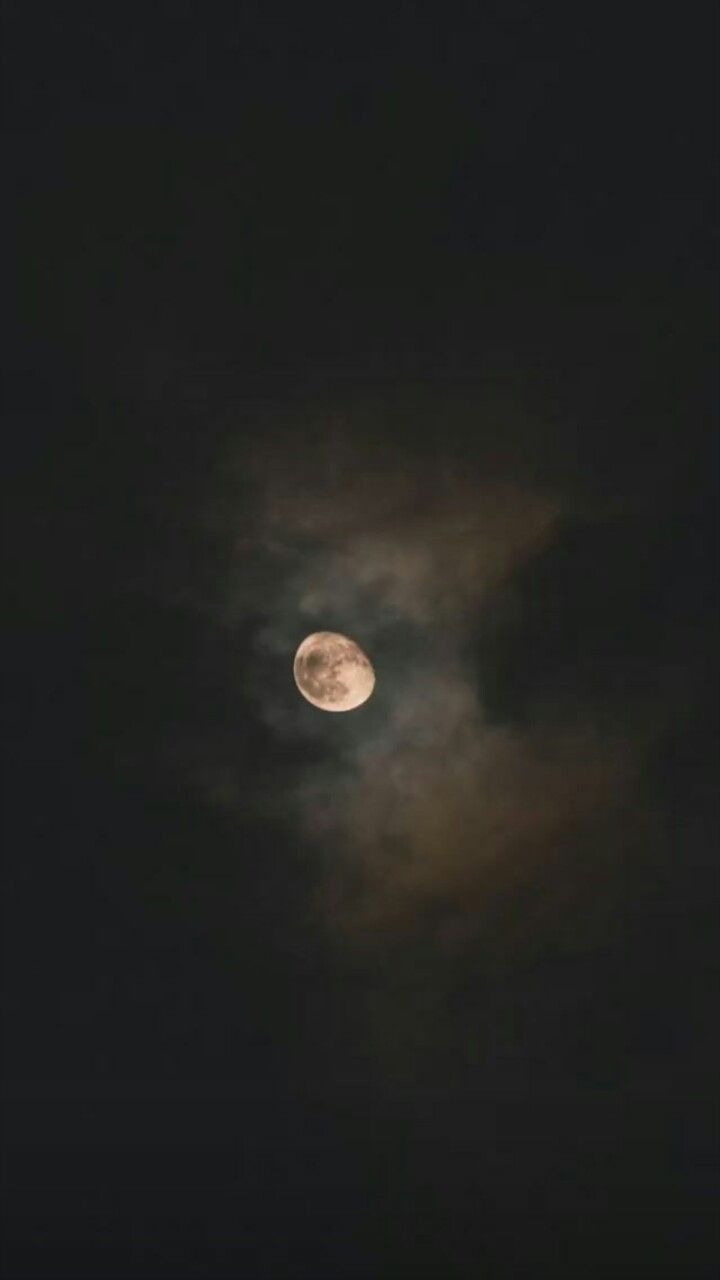 the full moon is visible in the dark night sky with white clouds and black background