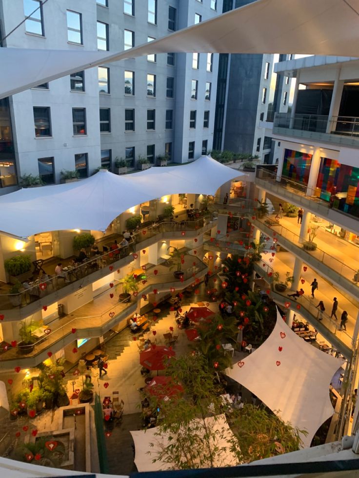 an overhead view of a shopping mall with lots of tables and umbrellas in the center