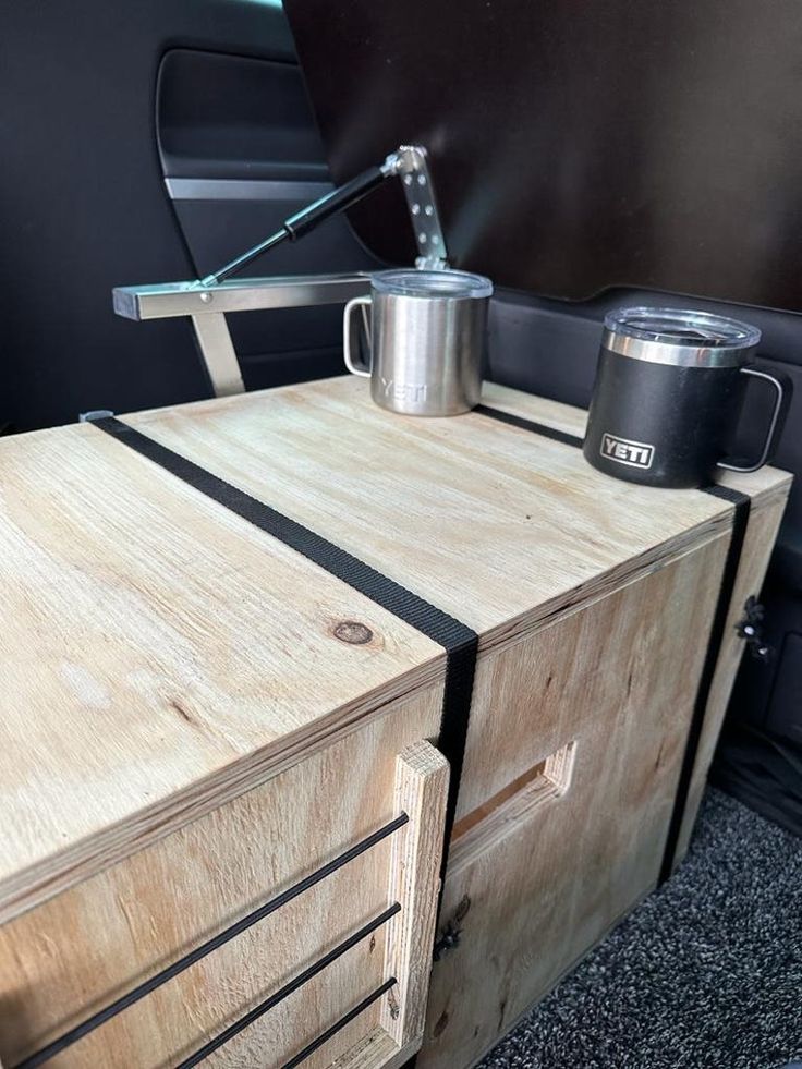 a coffee cup is sitting on top of a wooden cabinet in the back of a car