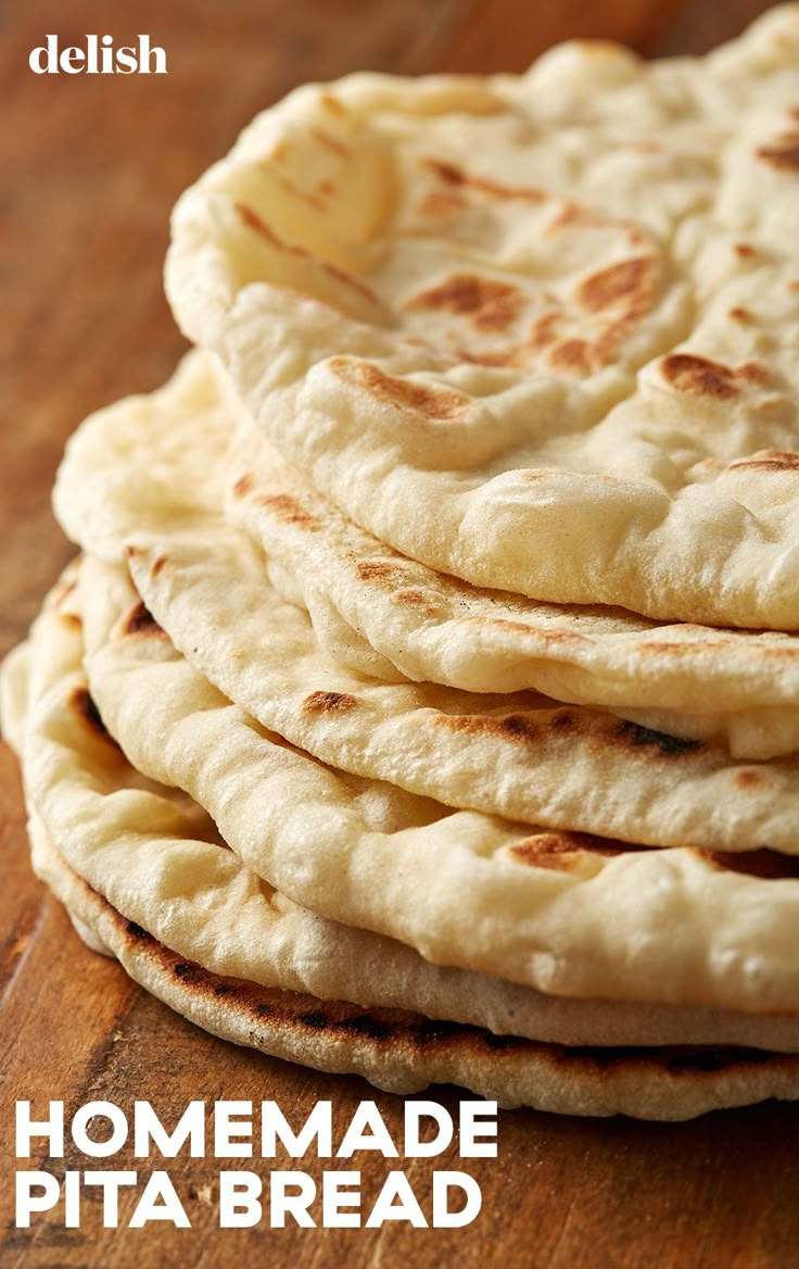 a stack of pita bread sitting on top of a wooden table