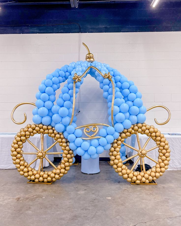 a balloon horse drawn carriage with blue and gold balloons