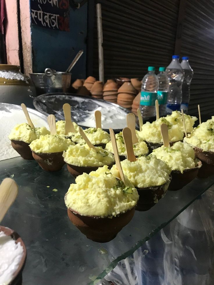 cupcakes are lined up with toothpicks in them on a glass table