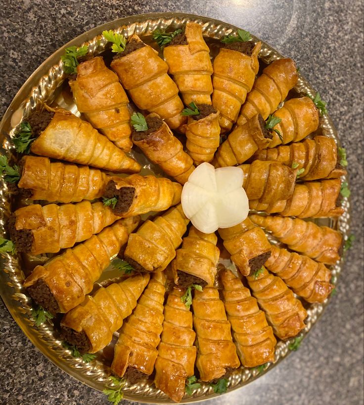 a platter filled with croissants covered in lettuce and cheese