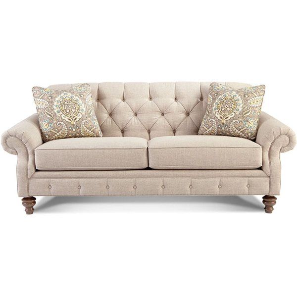 a beige couch with two pillows on it