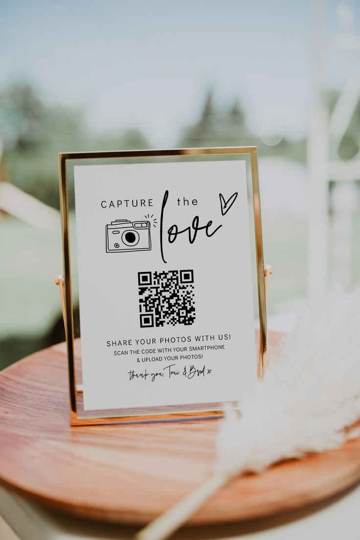 a sign that is on top of a wooden table in front of a window with white feathers