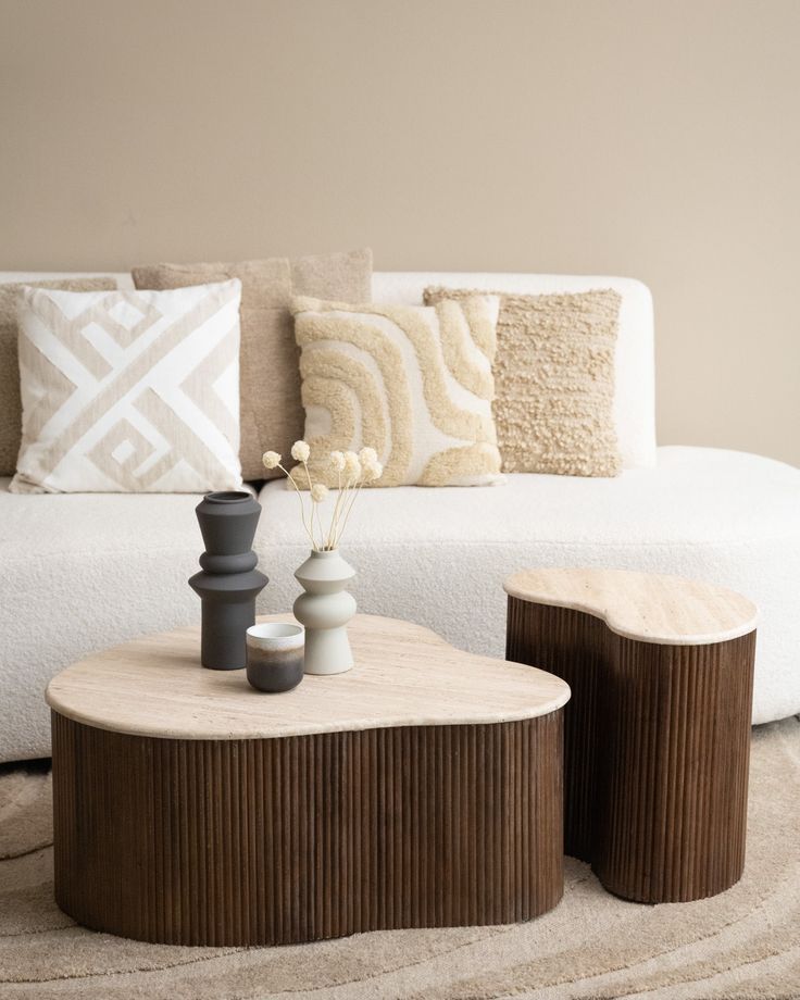 a white couch sitting next to a wooden table on top of a rug