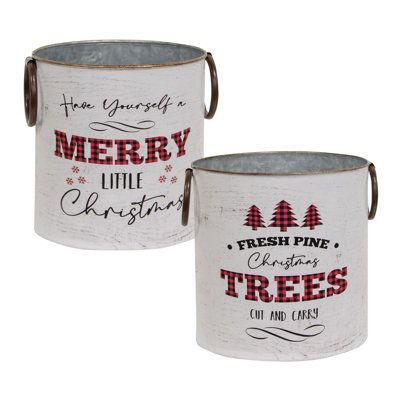 two white metal christmas buckets with merry little christmas trees on the front and back