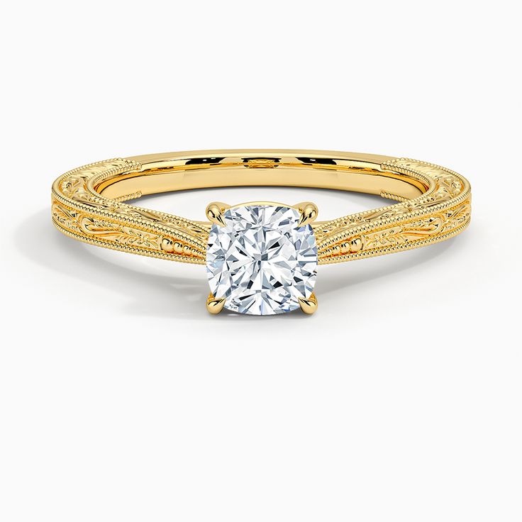 a yellow gold engagement ring with a diamond in the center and an intricate band around it