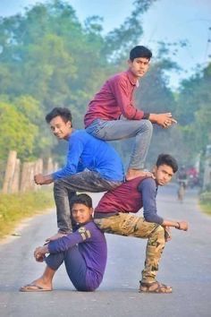 four young men are posing on the road