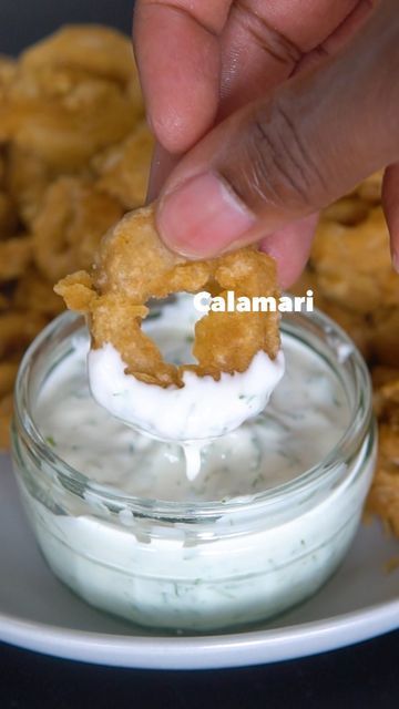 a person dipping some food into a small bowl