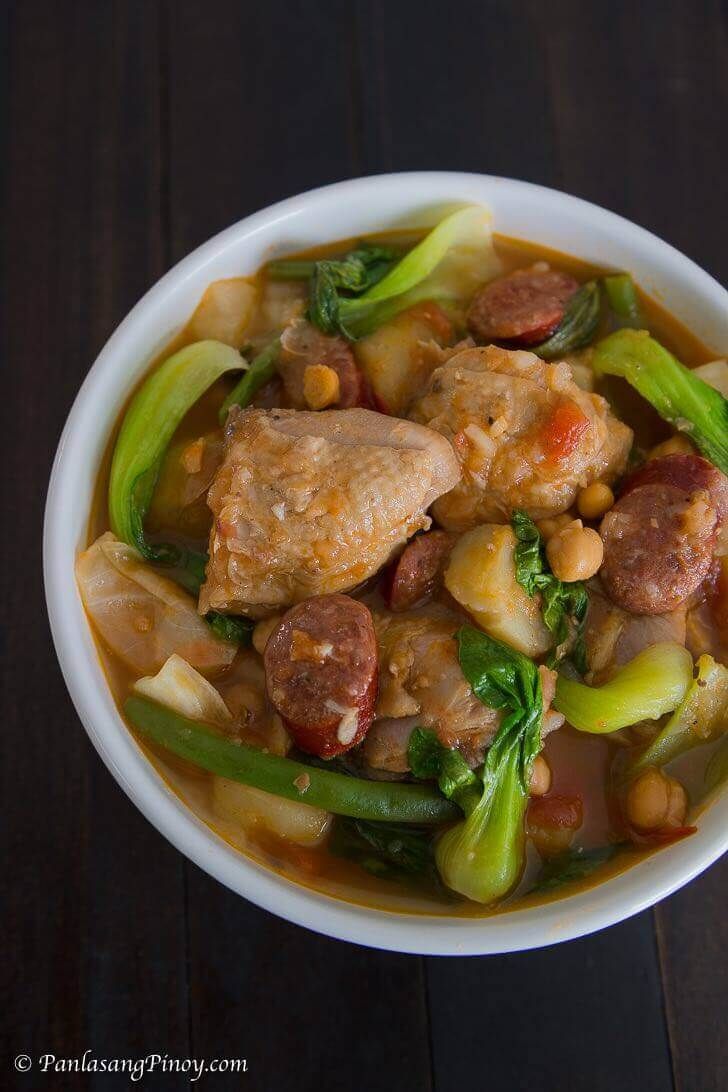 a white bowl filled with meat and vegetables