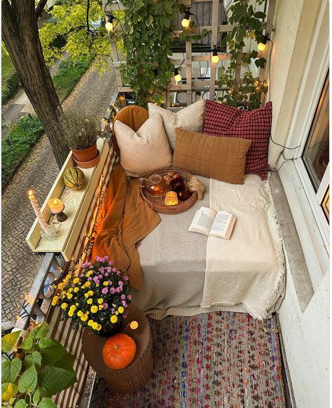 a bed sitting on top of a wooden floor next to a planter filled with flowers