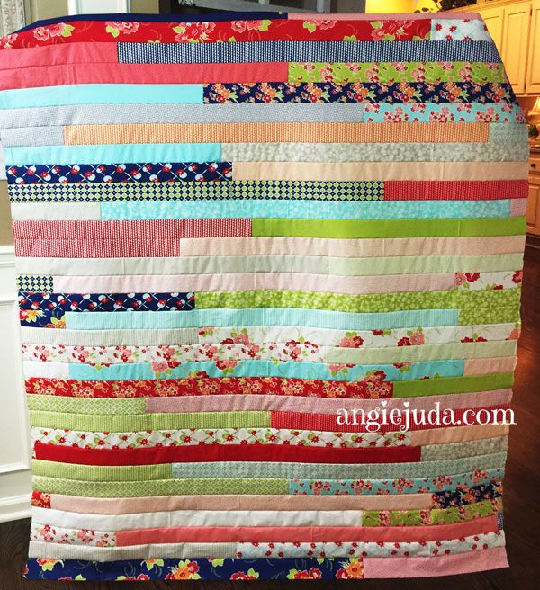 a colorful quilt hanging from the side of a kitchen counter