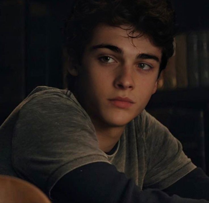 a young man sitting at a table in the dark