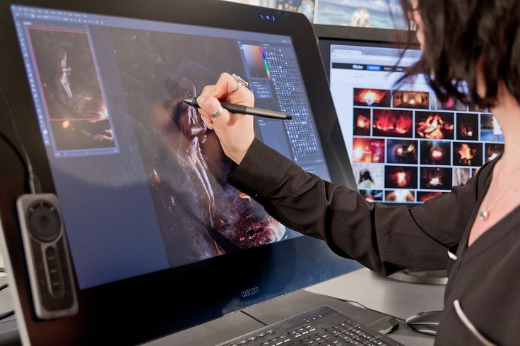 a woman is drawing on a computer screen