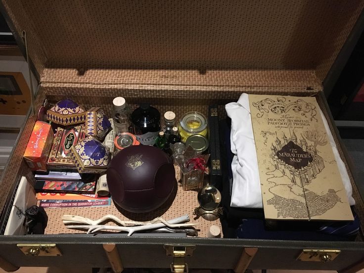 an open suitcase filled with lots of items like books, pens, and other things