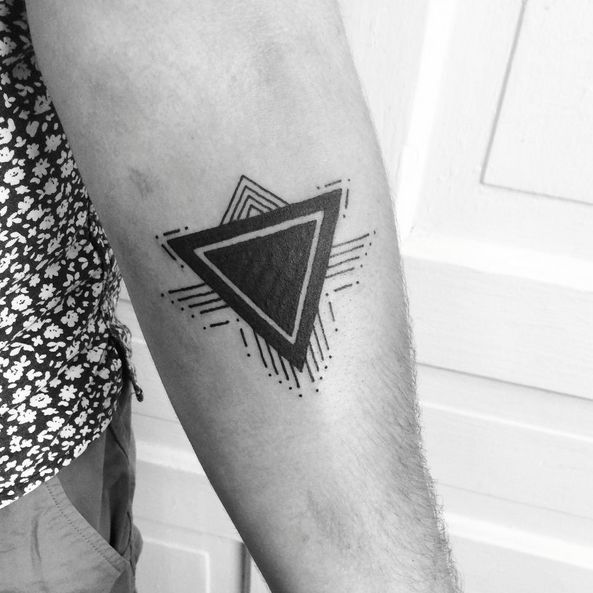 a black and white photo of a man's arm with a triangle tattoo on it