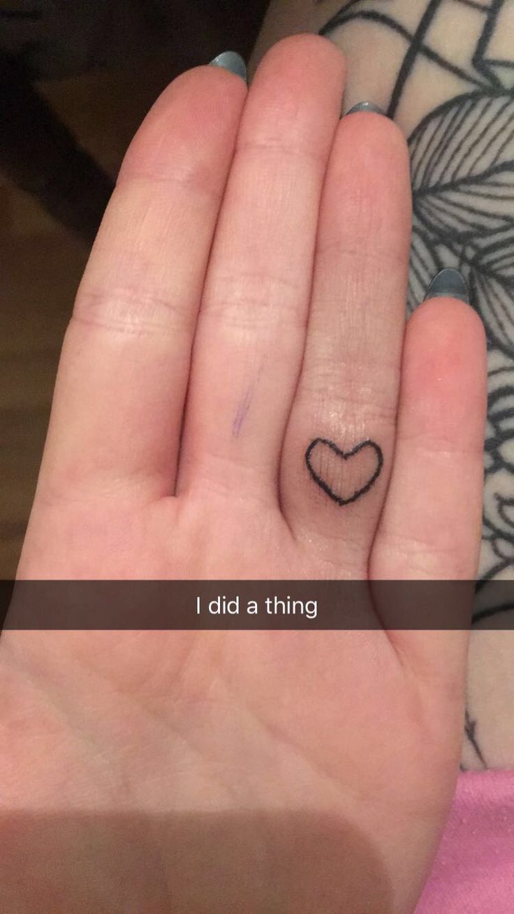 a person's hand with a small heart tattoo on the middle finger and i did a thing