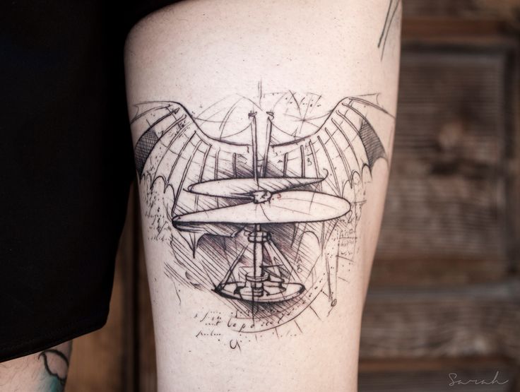 a tattoo on the leg of a man with an airplane and wings design in black ink