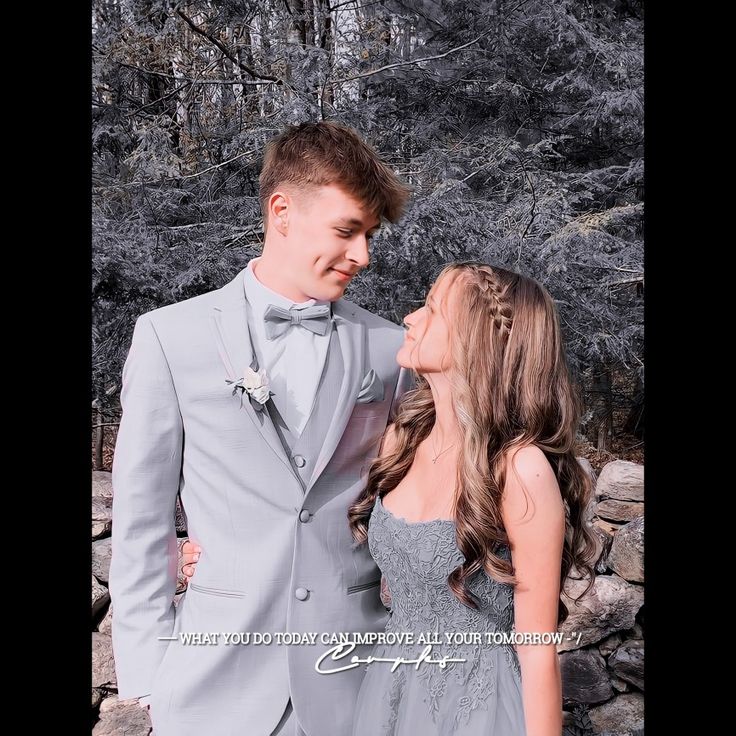 a young man and woman in formal wear standing next to each other with trees behind them