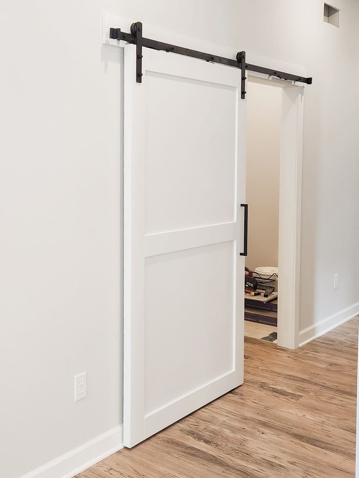 an empty room with two sliding doors and hard wood flooring on the side of the room