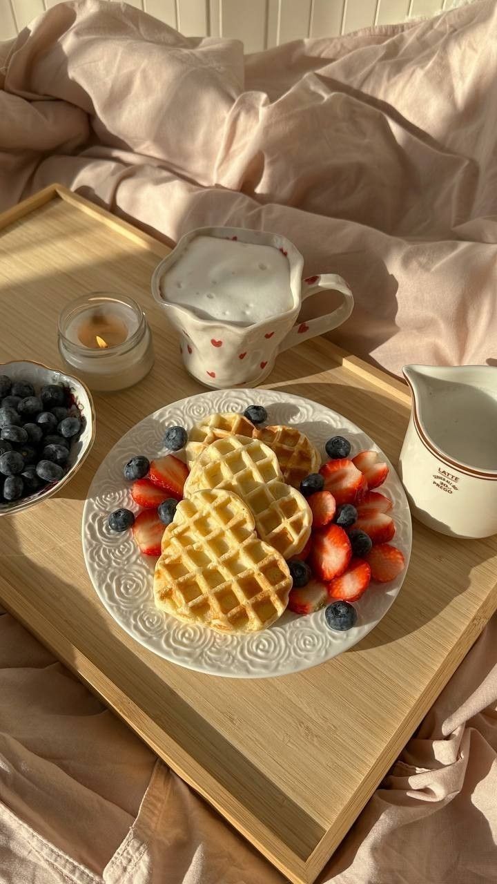 a plate with waffles, strawberries and blueberries on it