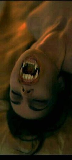 a person laying on the ground with their mouth open and teeth wide open in front of them