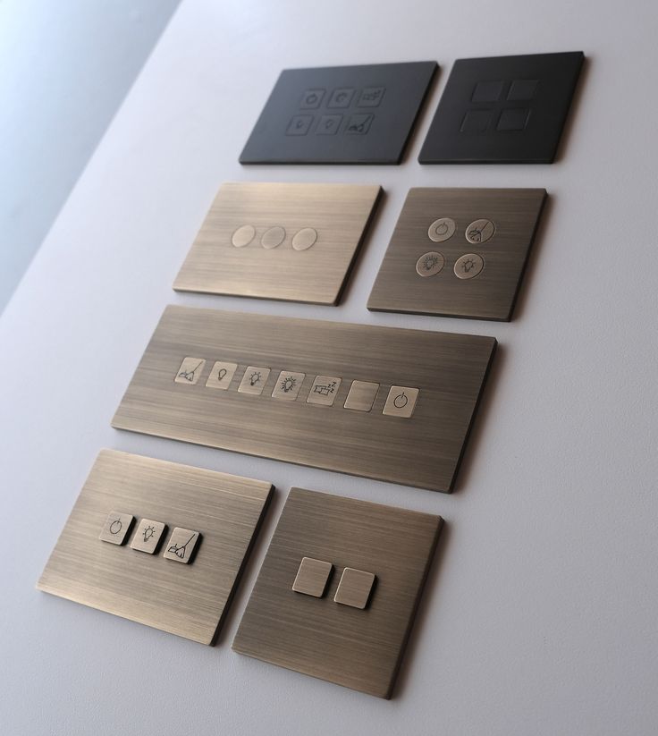 four different types of metal buttons on a white counter top with black and silver plates