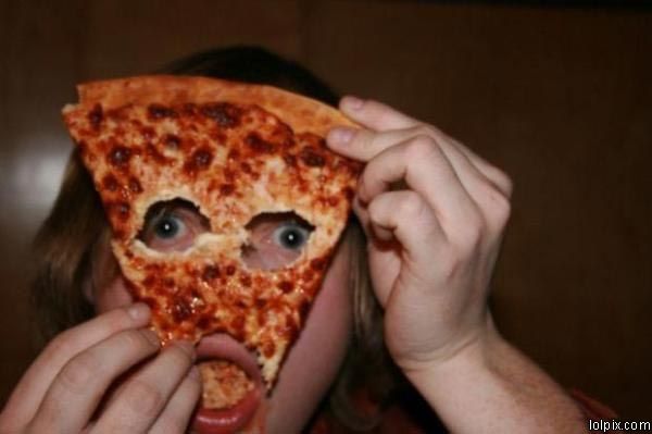 a person holding up a slice of pizza to their face