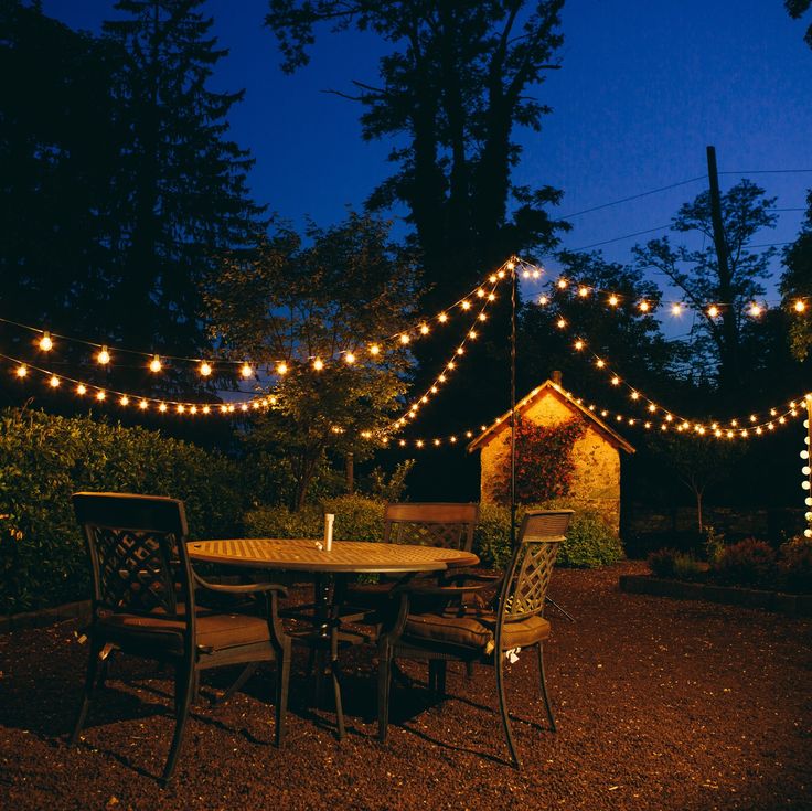 an outdoor dining area with string lights strung over it