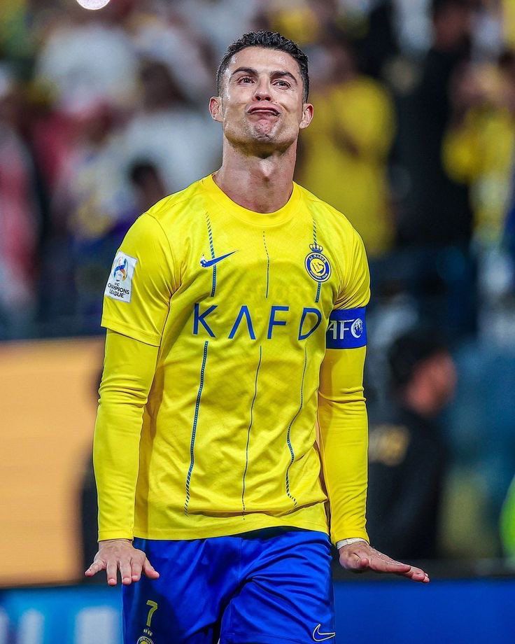 a soccer player in yellow and blue is looking up at the sky with his hand on his hip