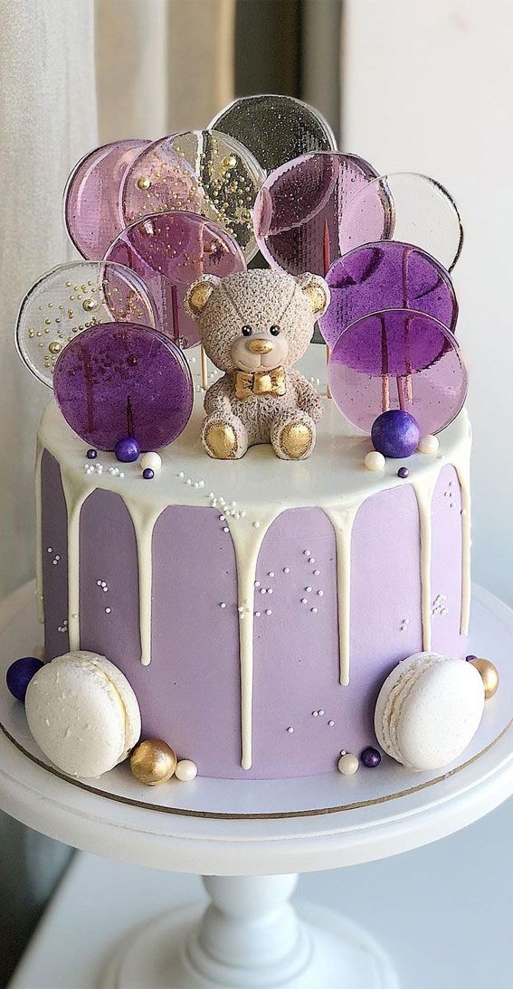 a purple and white cake with decorations on top