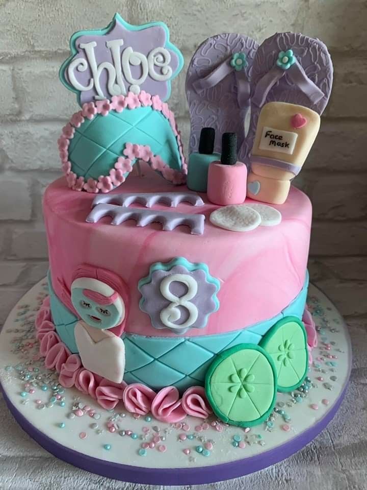 a birthday cake decorated with pink, blue and green items for a child's first birthday