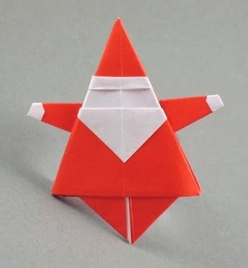 an origami red star with white stripes on the top and bottom, sitting on a gray surface