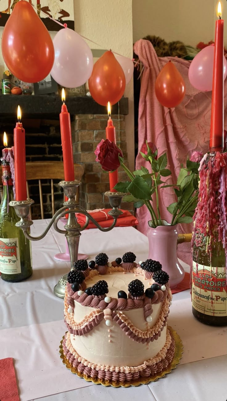 a decorated cake on a table with wine bottles and balloons in the background at a birthday party