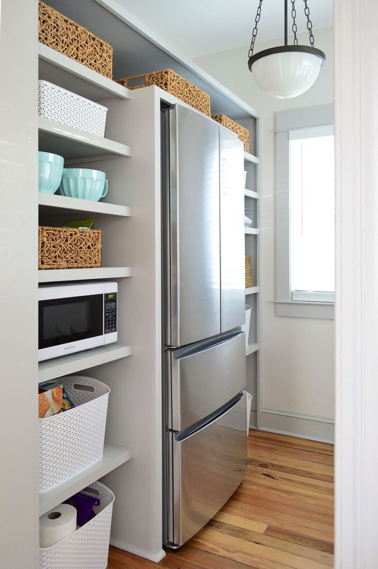 a stainless steel refrigerator freezer sitting inside of a kitchen next to a wooden floor