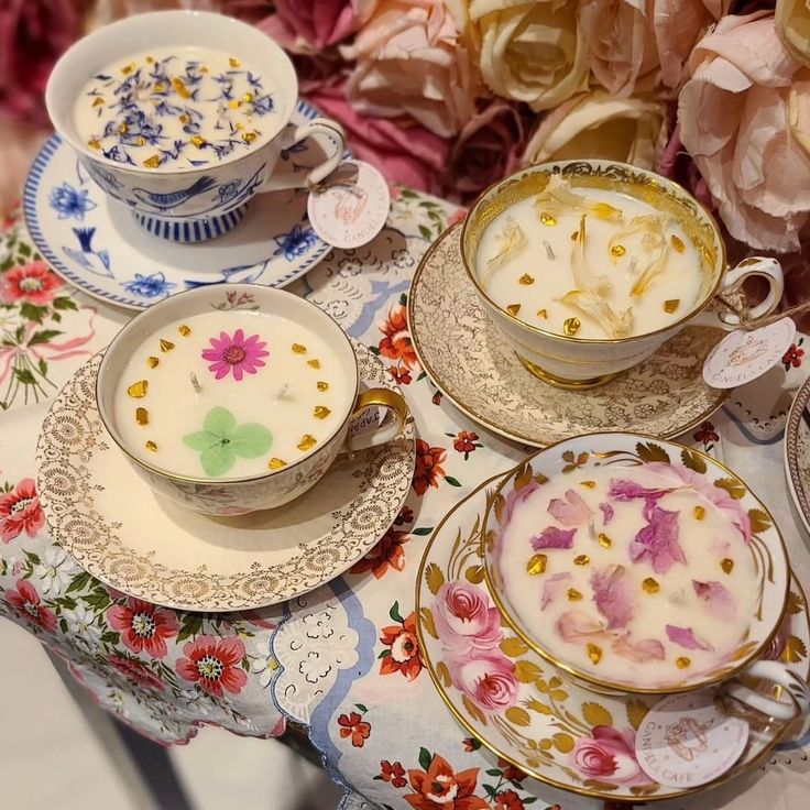 a table topped with plates and bowls filled with food next to pink flowered flowers