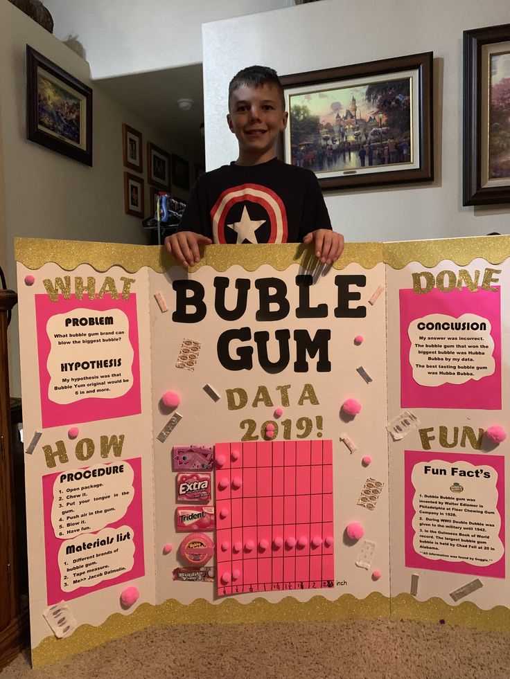 a young man holding up a bulletin board that says bubble gum data 2019 on it