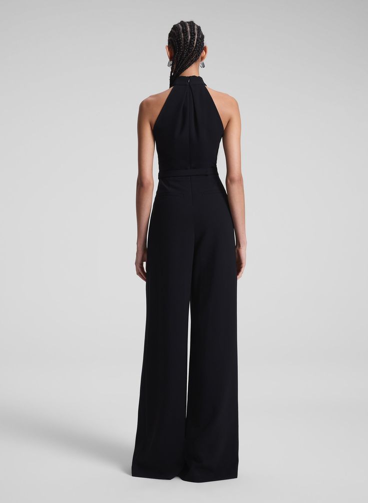 The Murphy II Jumpsuit is crafted from our luxurious silk cady in timeless black. This precise silhouette features an overlapping halter neckline, a slimmer belted waist than the original Murphy Jumpsuit, and pleated wide legs. Side slash pockets and back welt pockets complete the look, offering a seamless blend of elegance and functionality. Shop Jumpsuits. Styling Tip: Style it with bold statement earrings and a metallic clutch for a sleek, head-turning holiday party look. Metallic Clutch, Party Look, Wide Legs, Halter Neckline, Party Looks, Wide Leg Jumpsuit, Black Jumpsuit, Welt Pockets, Holiday Party